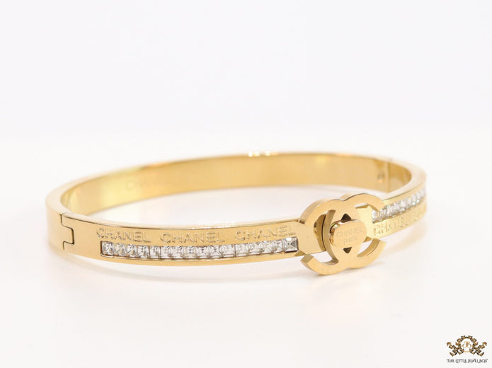 Gold plated bracelet with cz, inscribed alphabets and twin disc motif