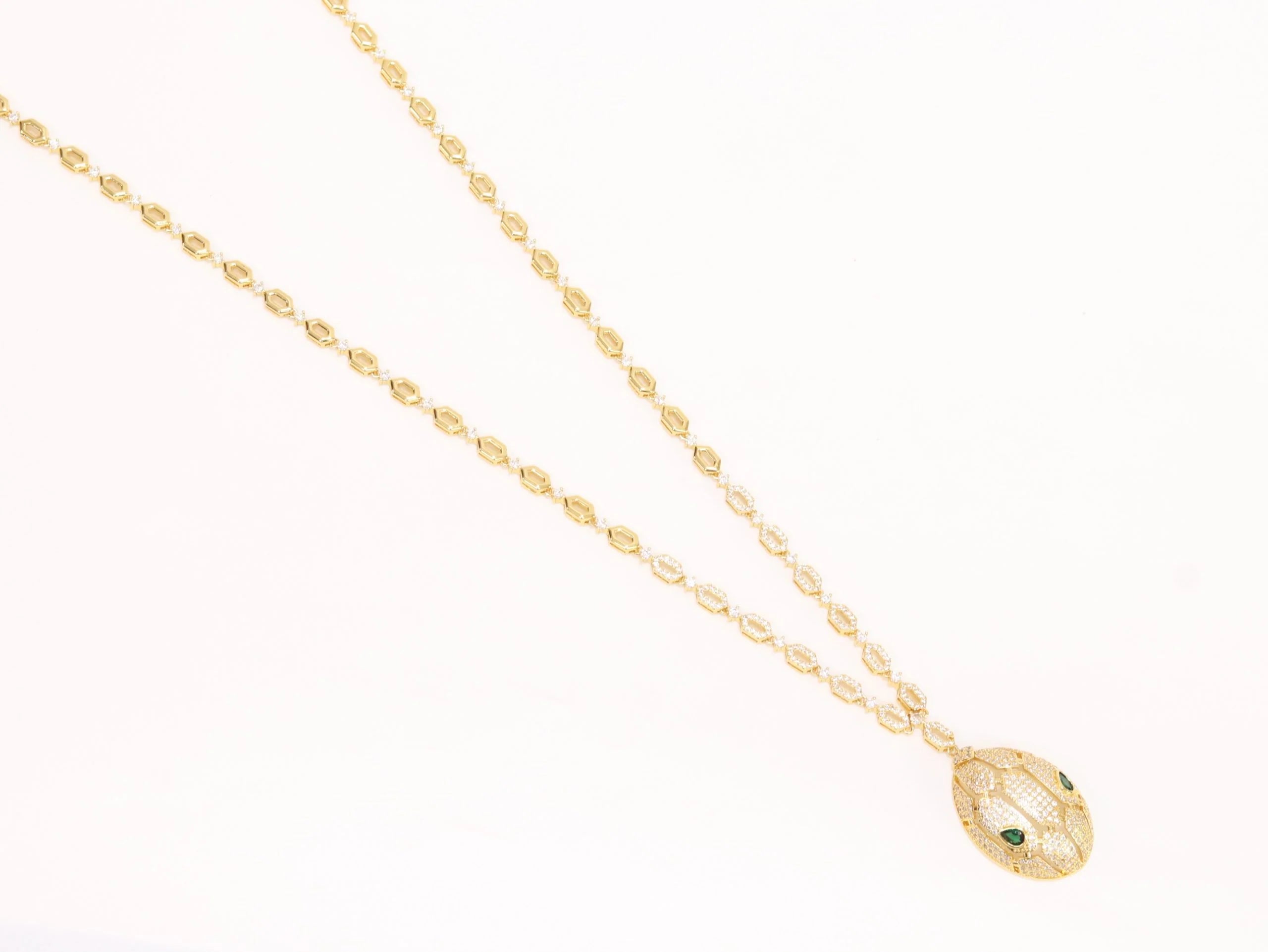 Gold Snake head pendant set with emerald detailing
