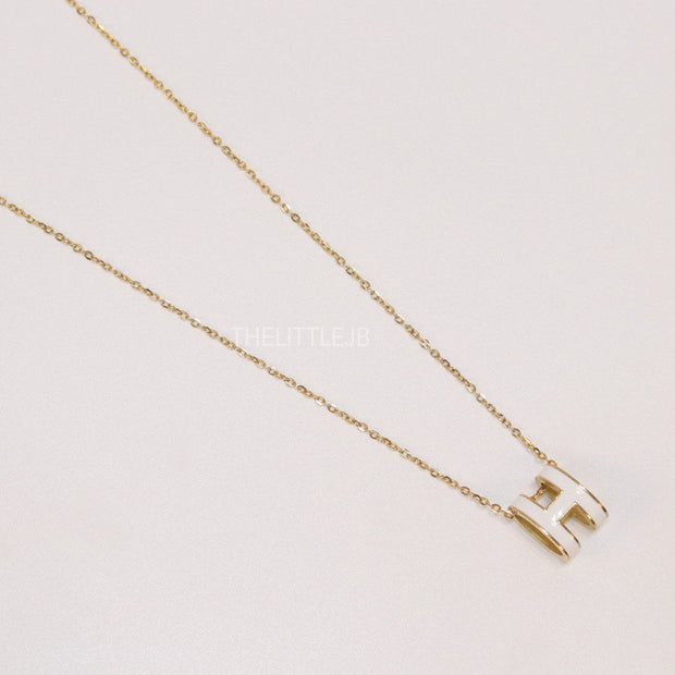 Gold chain necklace with white enamel H motif