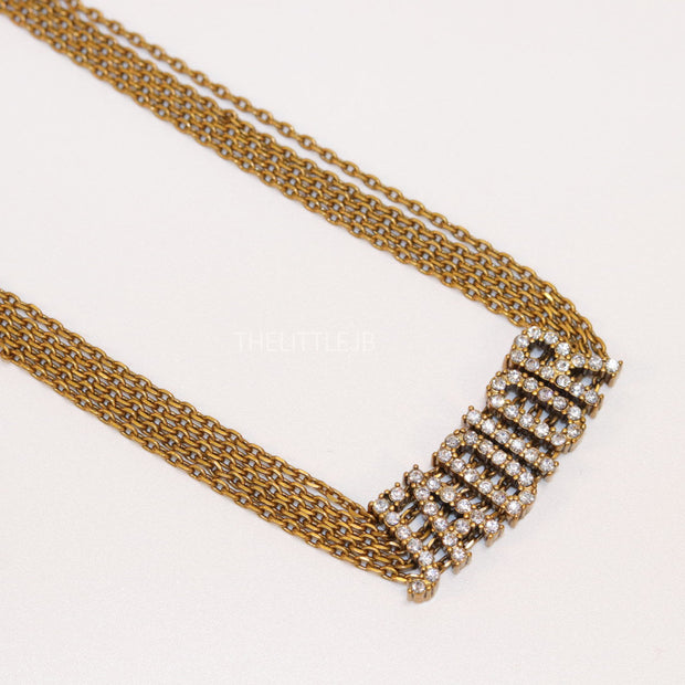Golden multi chain choker necklace with alphabet motif in cz