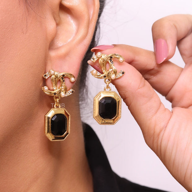 Gold Double C earrings with black enamel hanging