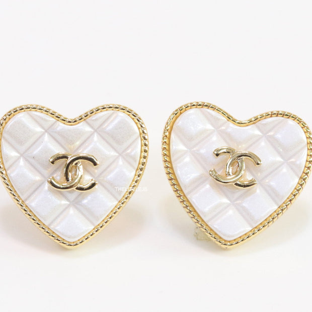 White textured heart shaped studs with twin C motif in golden finish