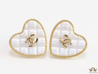 White textured heart shaped studs with twin C motif in golden finish