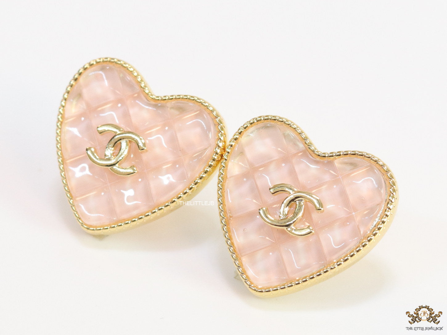 Light pink textured heart shaped studs with twin C motif in golden finish