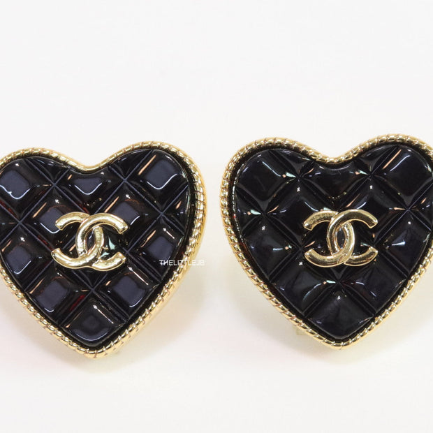 Black textured heart shaped studs with twin C motif in golden finish