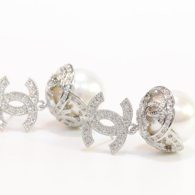 Platinum plated twin C earrings in cz with cz capped pearl drop