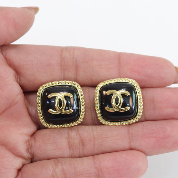 Twin C motif square studs in golden and black finish