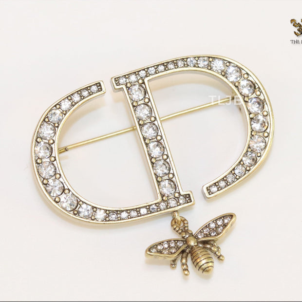 Alphabet C and D brooch in gold finish with dragonfly and cz