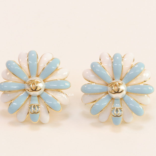 Off-white and soft blue daisy studs with golden details twin alphabet double C motif.