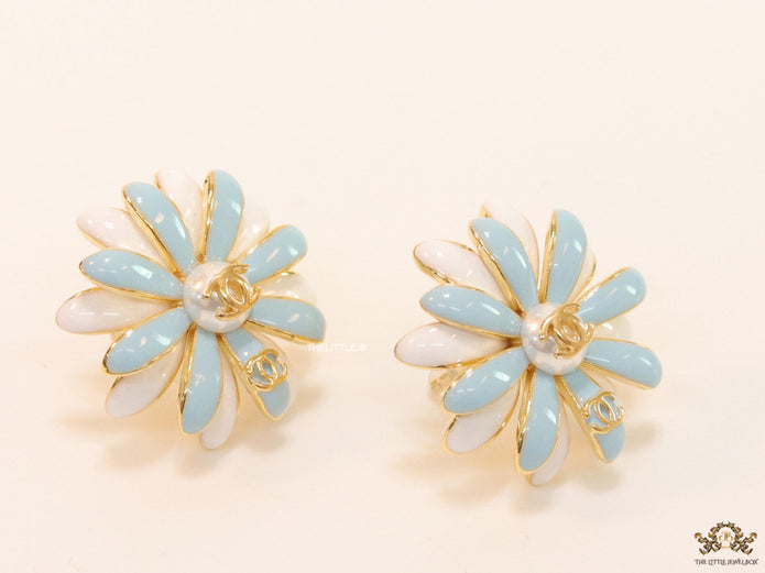 Off-white and soft blue daisy studs with golden details twin alphabet double C motif.