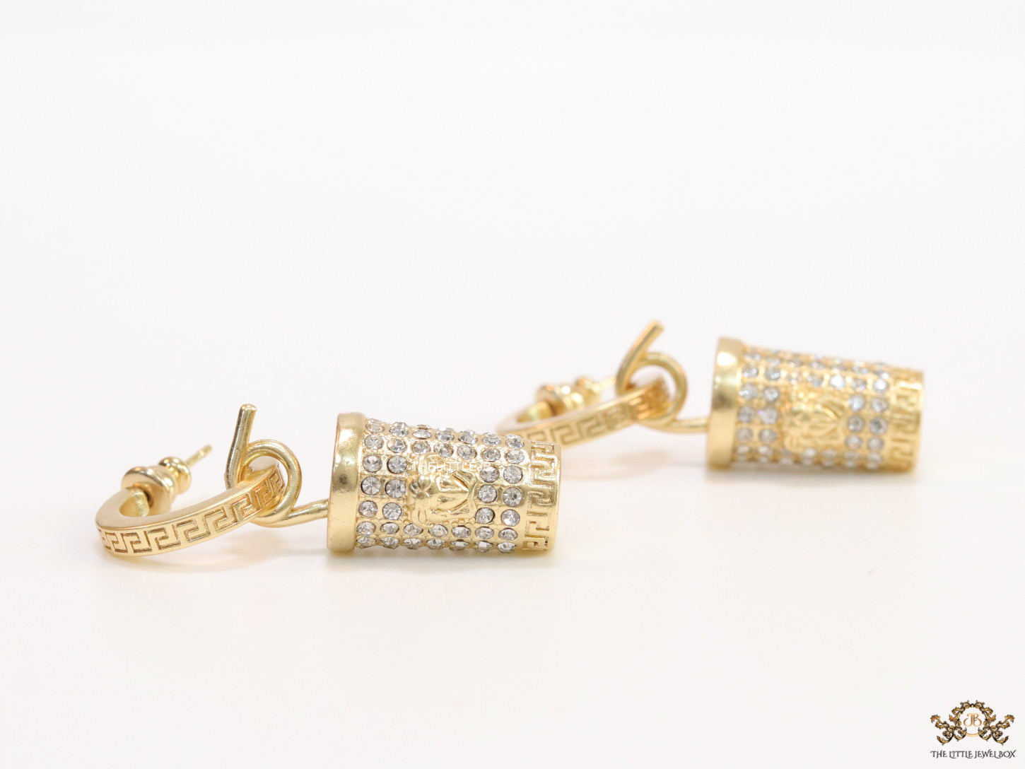 Gold plated hoop with cubic zirconia and 3d golden Medusa motif on cylidrical drop.