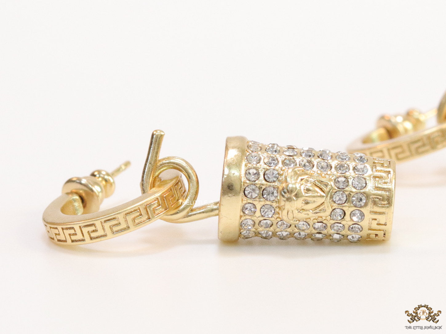 Gold plated hoop with cubic zirconia and 3d golden Medusa motif on cylidrical drop.