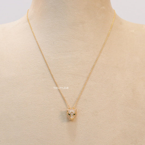 Gold plated cubic zirconia stones panther face motif pendant with emerald green stones details on sleek gold plated chain