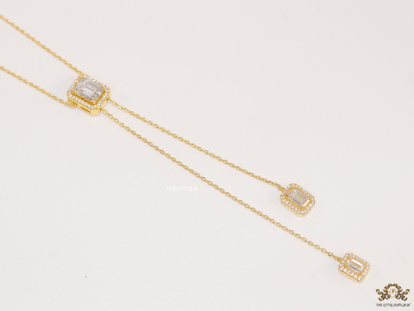 Emerald cut cubic zirconia stones in different sized on sleek gold plated chain