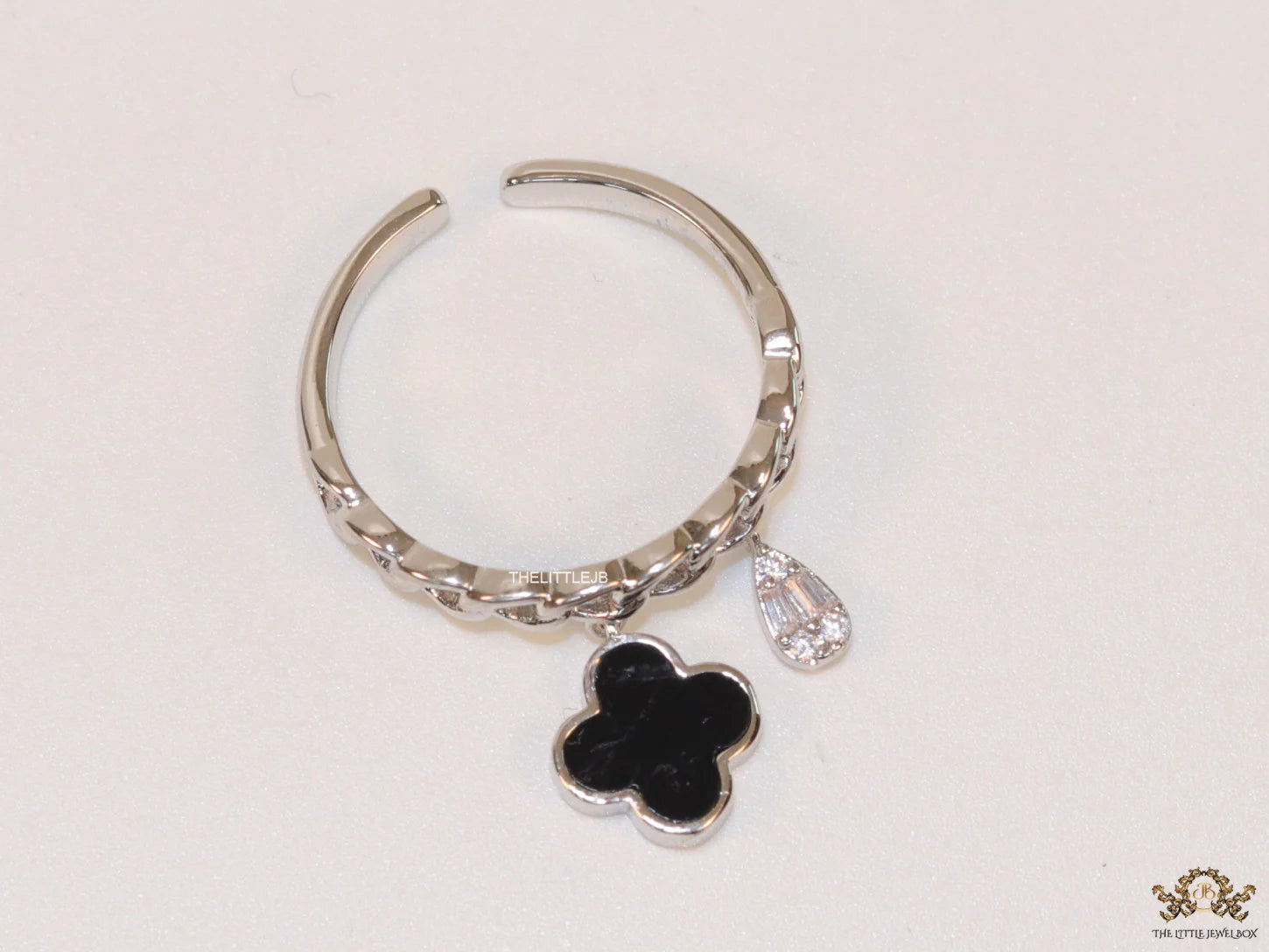 Platinum plated link chain ring with black clover and cz drop
