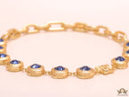 Gold plated link chain with blue cubic zirconia stones and gold plated Medusa motif charm.