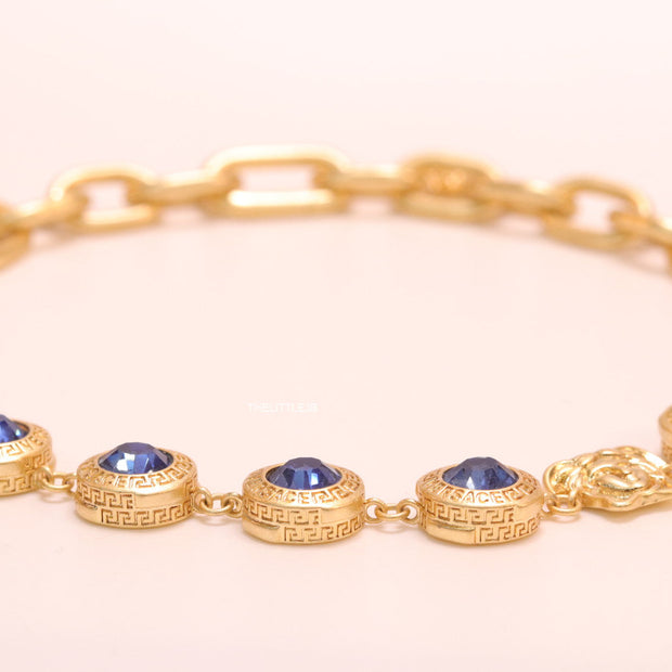 Gold plated link chain with blue cubic zirconia stones and gold plated Medusa motif charm.