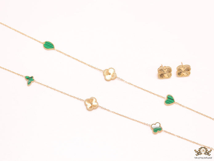 Emerald green clover heart and other shape charms on a sleek long gold plated chain with matching studs