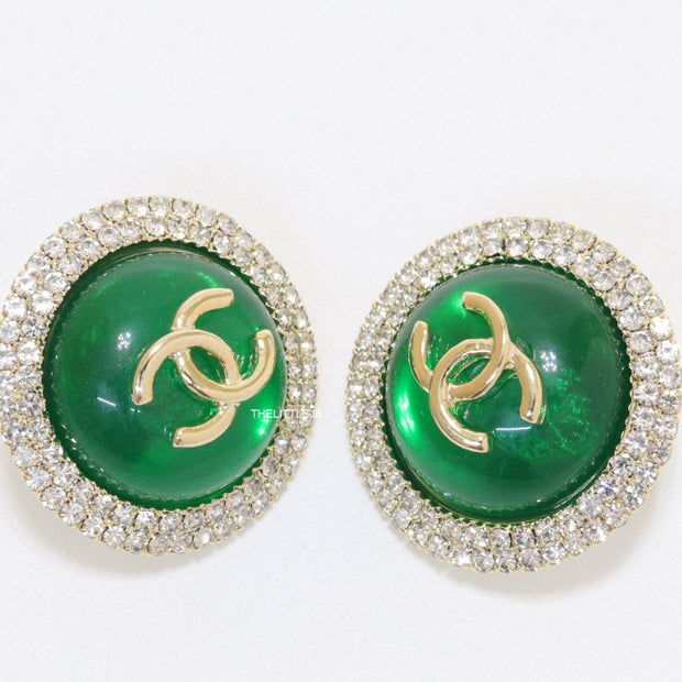 Round green stud earrings with twin C motifs lined with cz