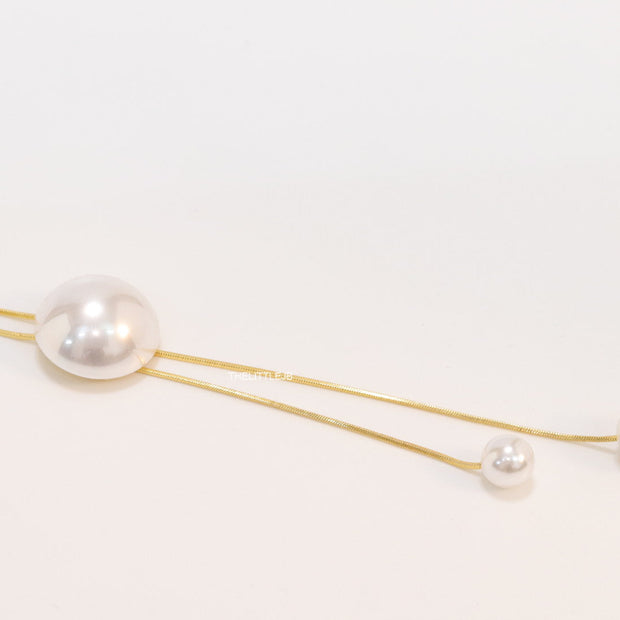 Sleek gold plated chain with different sized shell pearls.