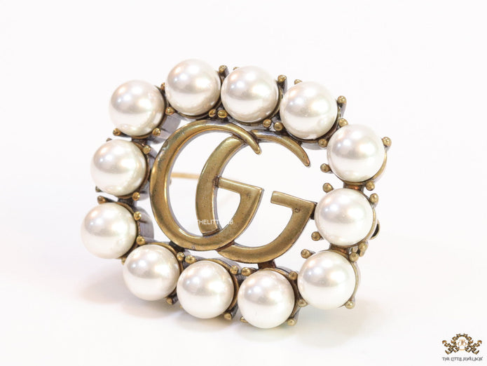 Pearls embraced alphabet brooch in gold finish