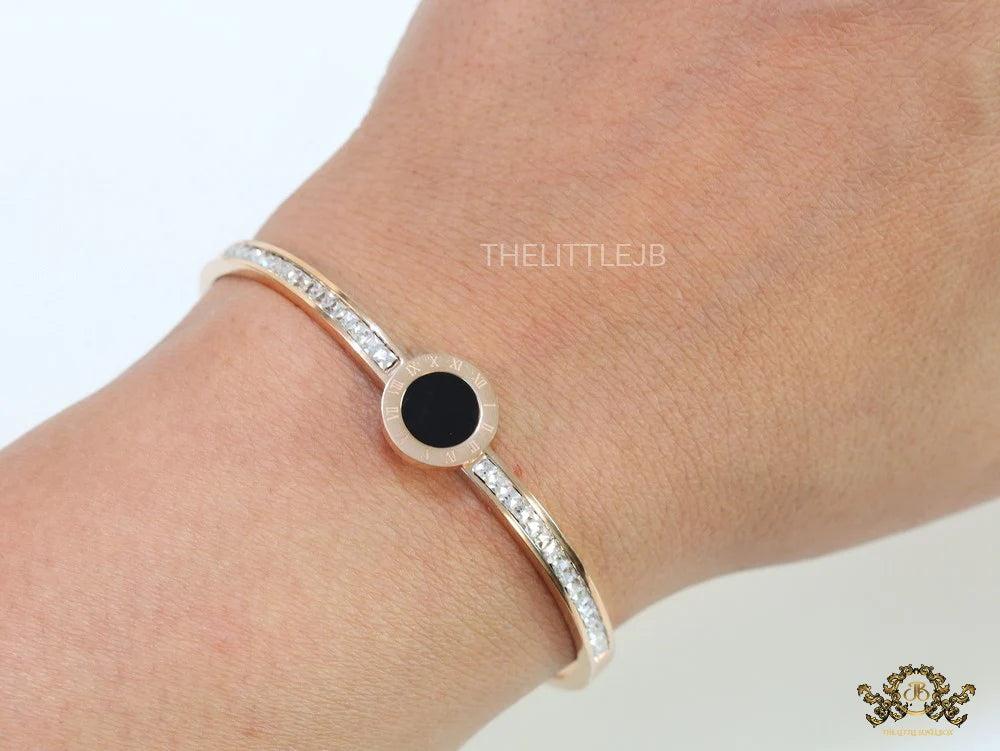 Rose gold plated cz bracelet with roman numerals inscribed on black centre motif