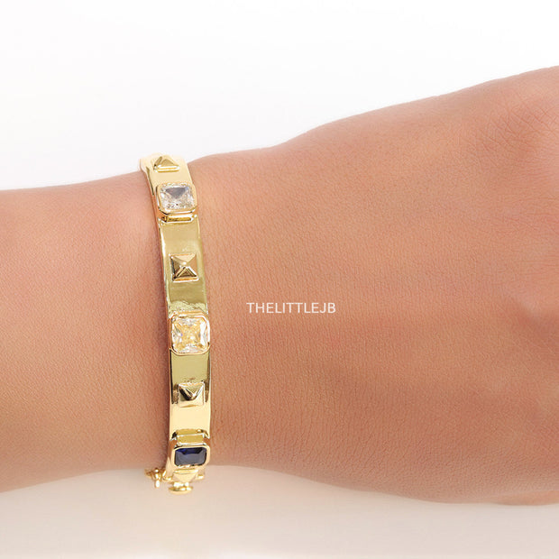 Band style bracelet in gold plating with gold plated details and multi colour stones