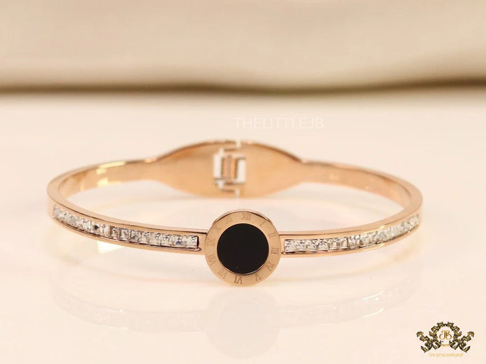 Rose gold plated cz bracelet with roman numerals inscribed on black centre motif