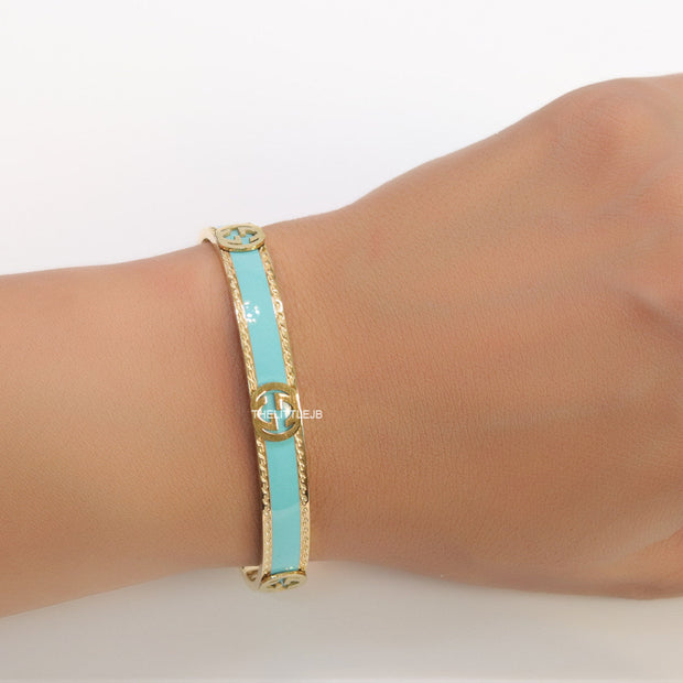Blue and golden open band bracelet with twin G alphabet motifs