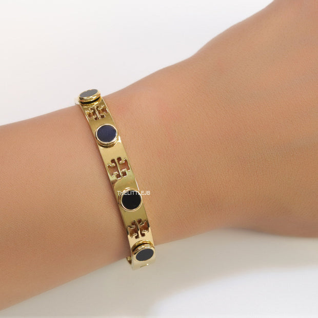 Gold plated cutwork twin T motif bracelet with black stones