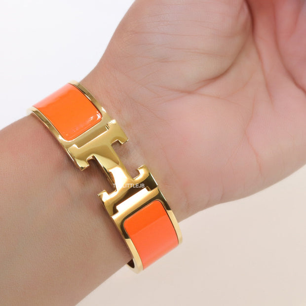 Openable H motif orange bracelet 18mm wide in a shiny gold plating