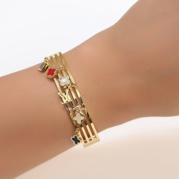 Multilayered golden bracelet with alphabets and coloured clover charms