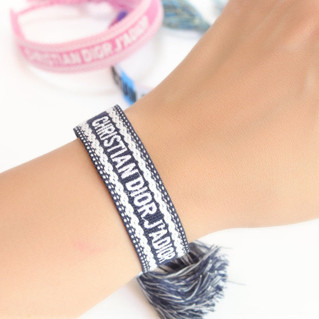 Adjustable dark grey woven bracelet with knitted alphabets and tassels