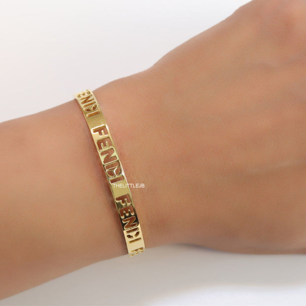 Gold plated open band bracelet with cutwork alphabets