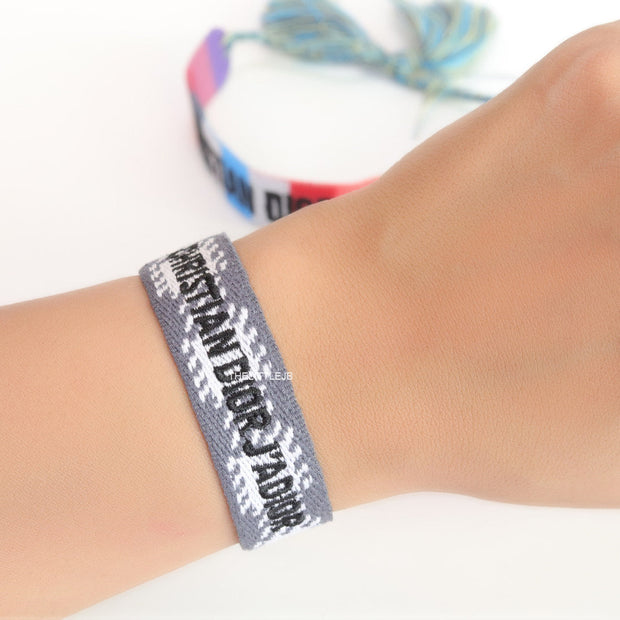 Woven grey bracelet band with black knitted alphabets