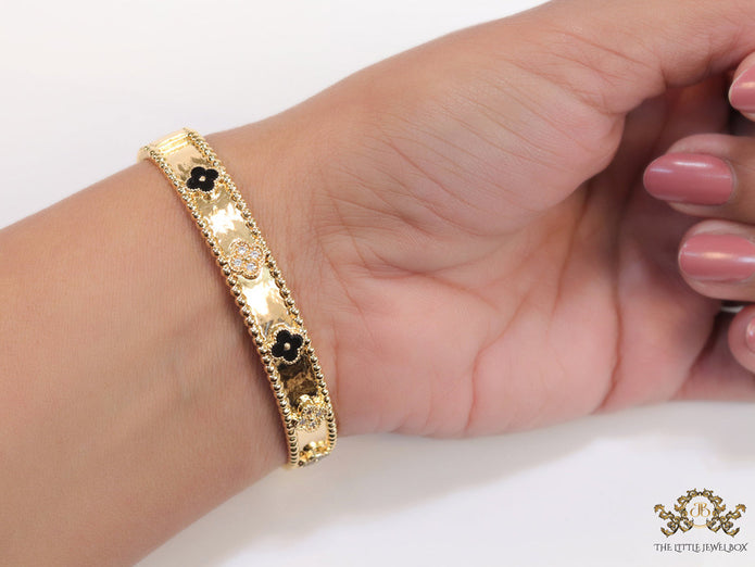 Gold plated bracelet with clover motifs in cz and black enamel