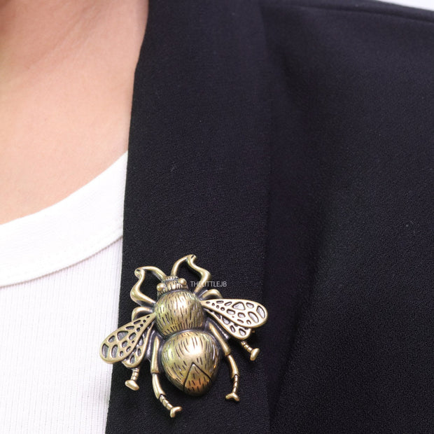 Antique gold finish bee brooch with white and red stones and blue details