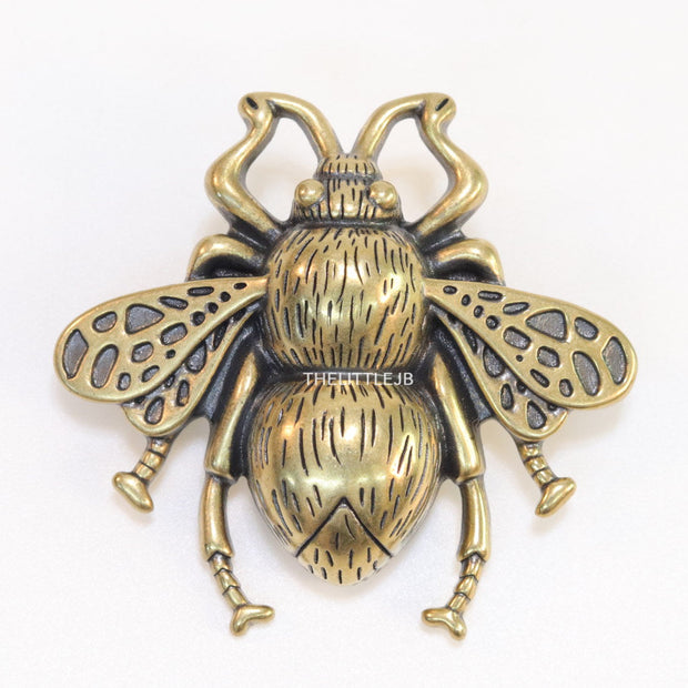 Antique gold finish bee brooch with white and red stones and blue details