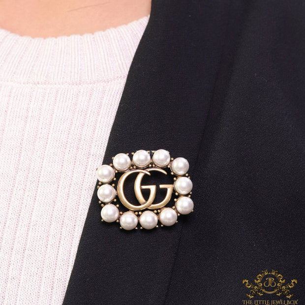 Pearls embraced alphabet brooch in gold finish