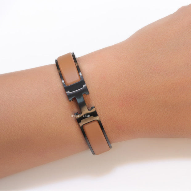 Premium collection band style bracelet in matt tan with black metallic details and black T alphabet motif