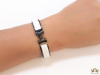Premium collection band style bracelet in matt white with black metallic details and black T alphabet motif