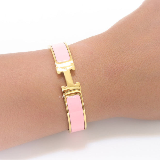 Premium range band style bracelet in pink colour with gold plated metallic details and gold plated T alphabet motif