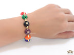 Gold plated link chain bracelet with multi coloured acrylic buttons with gold plated twin C alphabet