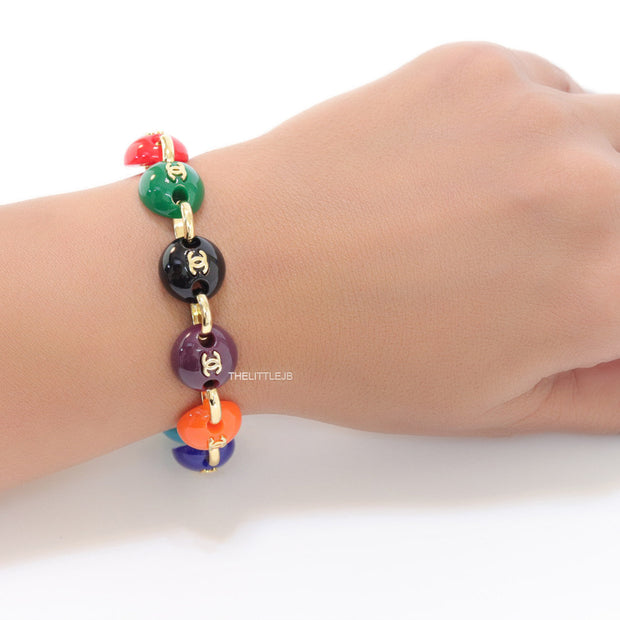 Gold plated link chain bracelet with multi coloured acrylic buttons with gold plated twin C alphabet