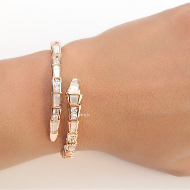 Open top rose gold plated minimal serpentine bracelet with cubic zirconia stones and pearl white stones.