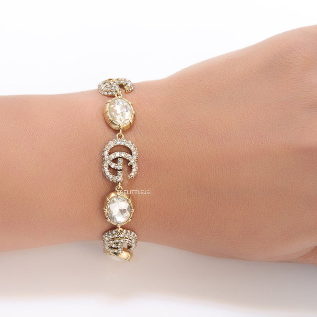 Gold plated linked chain bracelet with gold plated cubic zirconia stones twin G alphabet motifs and gold plated cubic zirconia stones