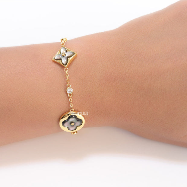 Sleek gold plated chain style bracelet with gold plated grey mother of pearl flower designs