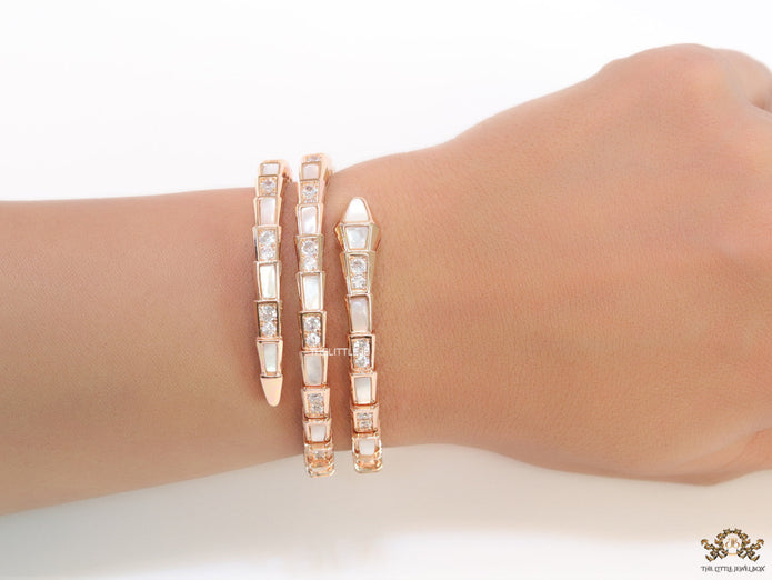 Triple line rose gold plated minimal serpentine bracelet with cubic zirconia stones and pearl white stones.