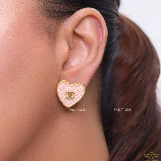 Light pink textured heart shaped studs with twin C motif in golden finish
