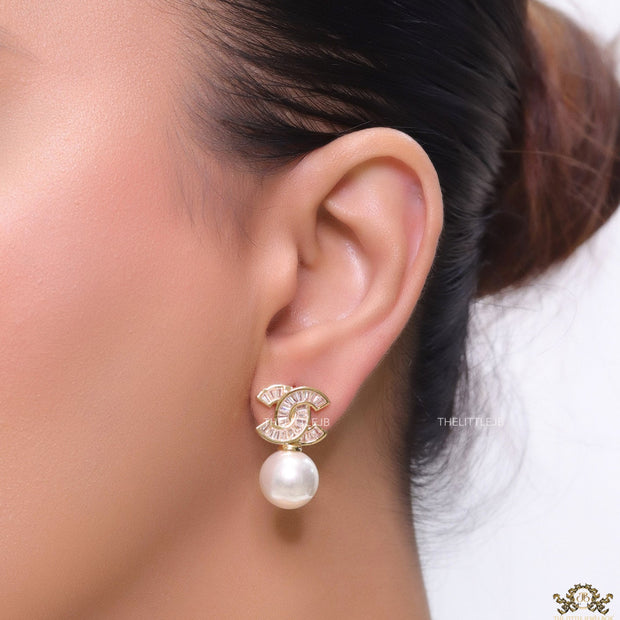 Golden cz baguettes studded twin C motif stud with pearl drop